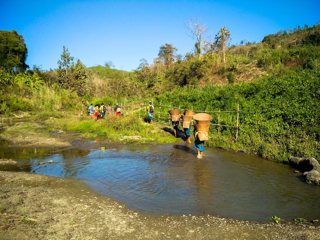 Ruma Bandarban 방글라데시 백힐 자연에서 큰 대나무 양동이를 걷는 부족 사람들