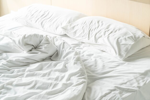 rumpled bed with white messy pillow 