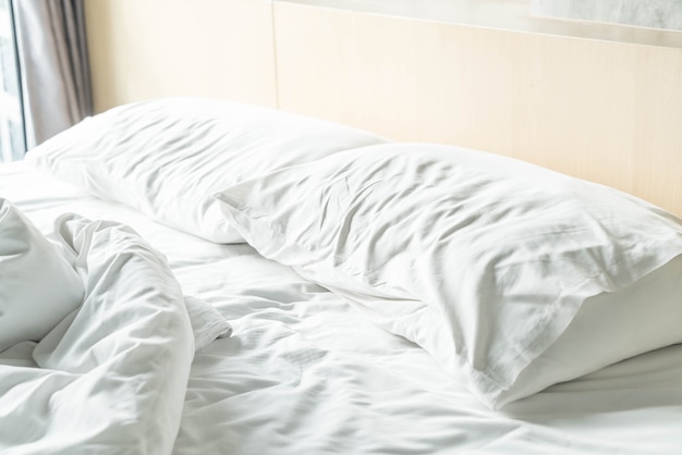 rumpled bed with white messy pillow 