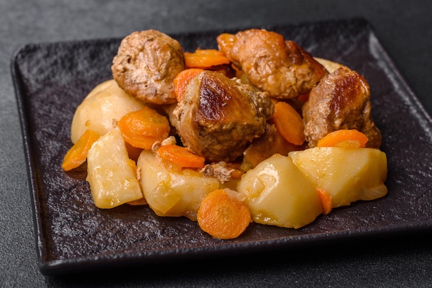 Rundvlees en groenten stoofpot op een zwarte plaat met geroosterde aardappelen
