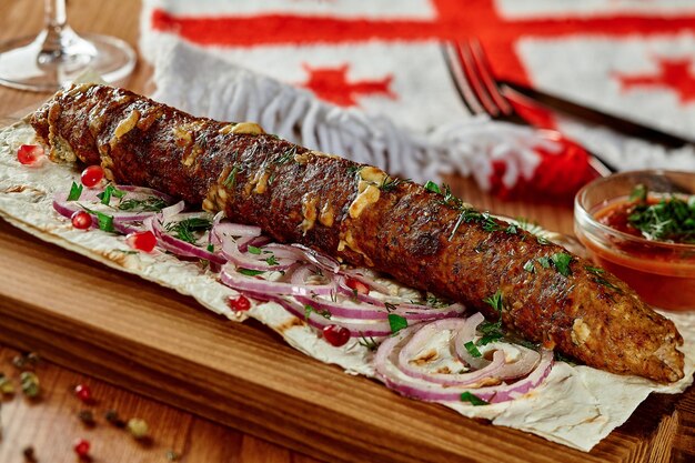 Foto rundvlees en kaaskebab met lavash-ui-granaatappelzaden en satsebeli in georgisch restaurant