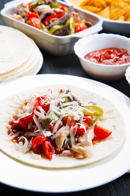 Rundvlees en kip Fajitas met kleurrijke paprika&#39;s in tortillabrood en sauzen