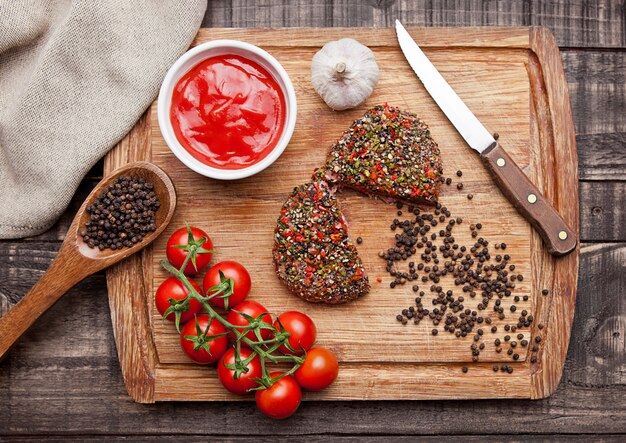 Rundvlees ruwe biefstuk met peper en tomaten op houten bord