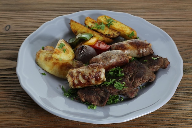 rundvlees tikka kabab en worst met aardappel groenten geserveerd in een gerecht geïsoleerd op de tafel uitzicht op Arabisch eten