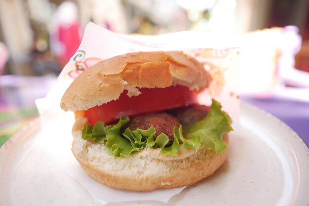 rundvleesburger met een papier op een bord buitencafé eten op straatconcept