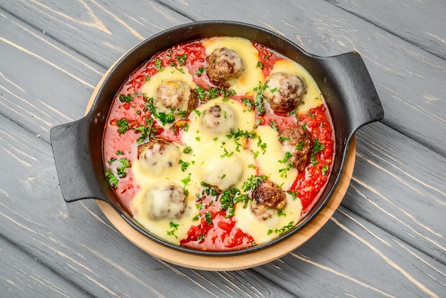 Rundvleesgehaktballetjes met tomatensaus en Parmezaanse kaas in pan