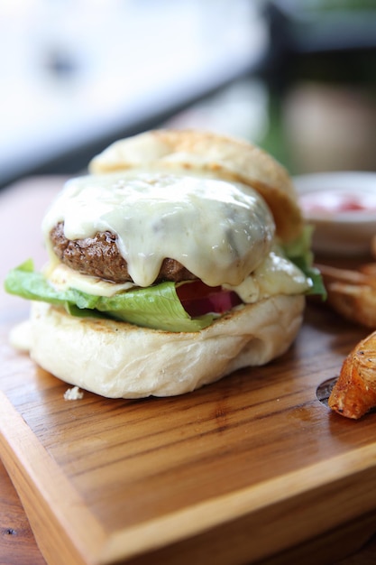 Rundvleeshamburger met kaas en vuren op houten achtergrond