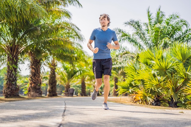 Runner athlete running at tropical park man fitness sunrise jogging workout wellness concept