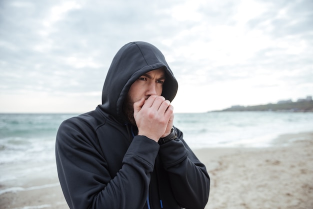 Runner on beach side view so cold