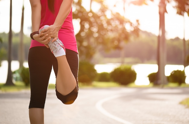 Runner benen strekken voordat uitvoeren in het park. Outdoor oefening concept.