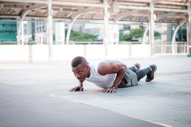 Runner doing strength training exercise push up at outdoor gym Young man exercise outdoors