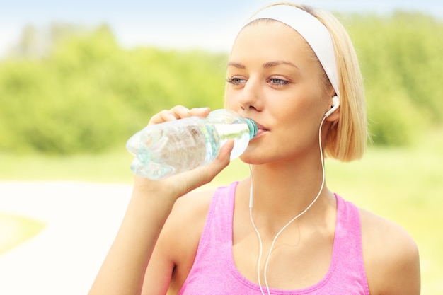 Runner drinkwater in het park