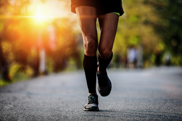 Runner feet running on asphalt road closeup 