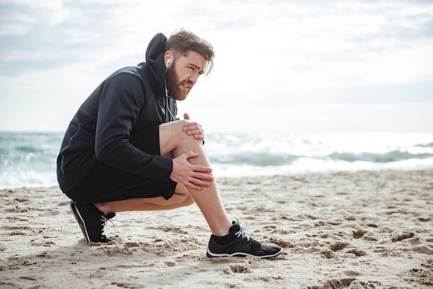 Runner gewond op strand zijaanzicht