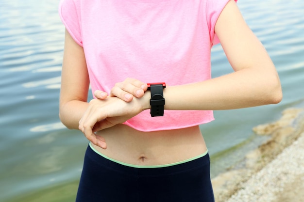 Runner looking at sports smart watch outdoors