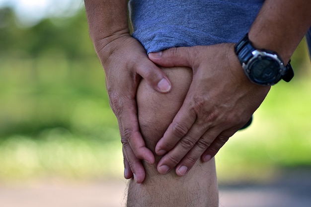 Runner man knee pain at running or jogging