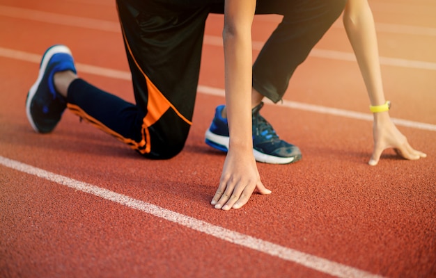 Runner man in start pose at the stadium,