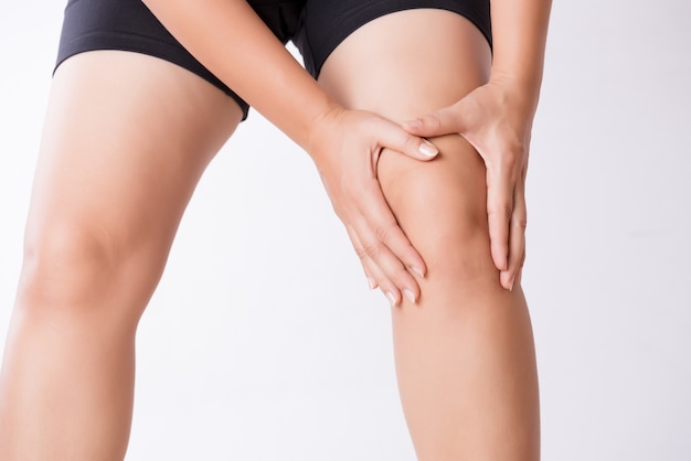 Runner sport knee injury. Closeup young woman in knee pain while running
