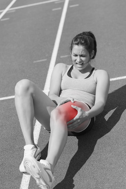 Photo runner suffering from leg cramp on the track