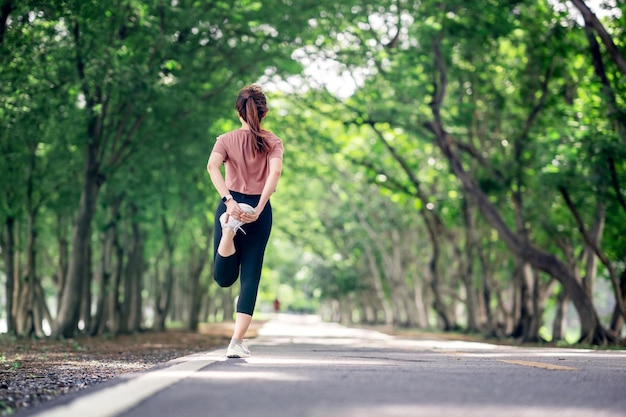 Runner vrouw die benen uitrekt voordat ze in het park rent