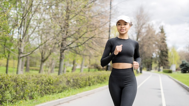 A runner woman is engaged in fitness running in comfortable sportswear a smart watch and a tracker on her hand