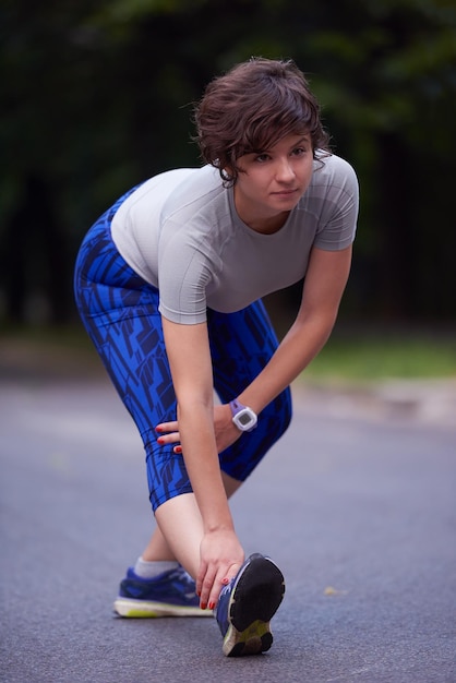 Foto corridore donna che si riscalda e si allunga prima di fare jogging mattutino