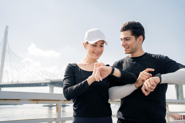 Runners are a man and a woman couple with a fitness smartwatch app and running time