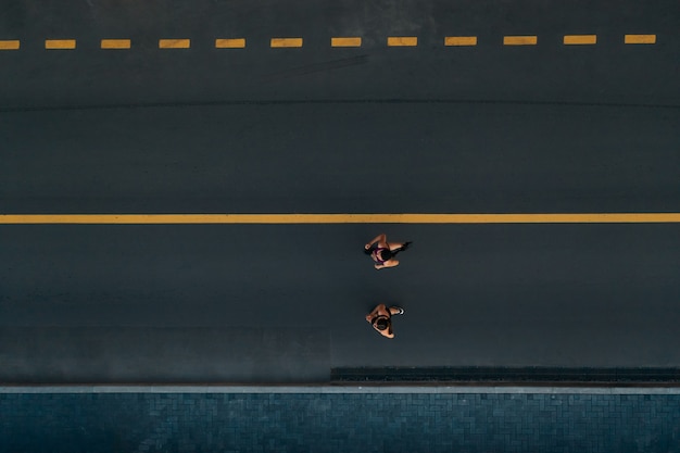 Runners running people fitness. healthy active lifestyle.\
active girls jogging together on road view from above.