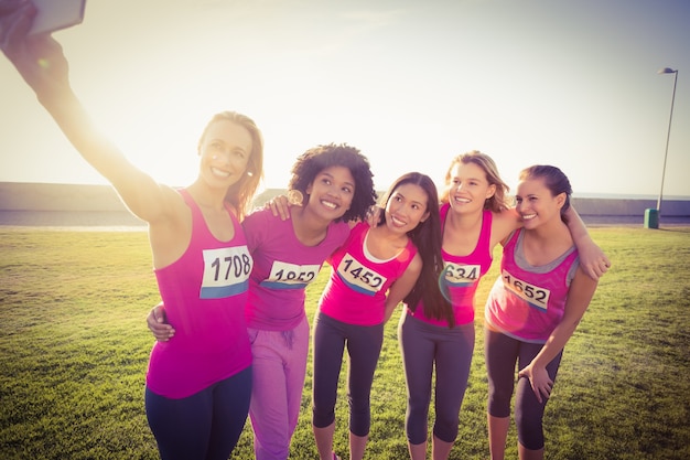 Runners supporting breast cancer marathon and taking selfies