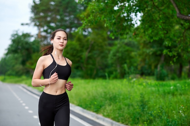 ランニングトラックでアジアの女性を実行しています。朝のジョギング。アスリートトレーニング