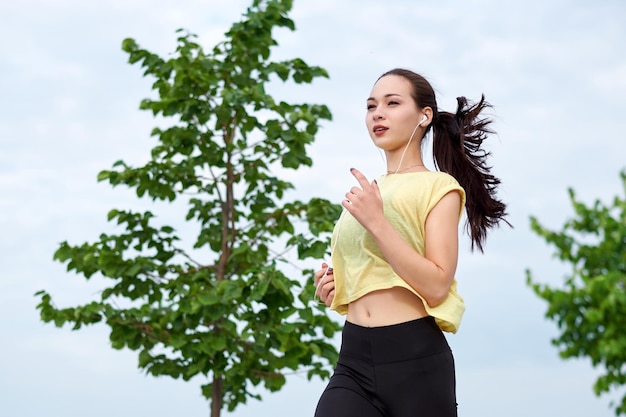 Running asian woman on the waterfront Morning jogging The athlete trains