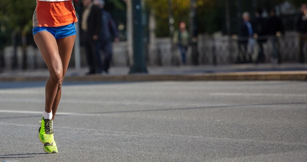 Running in the city roads Young woman runner front view banner blur background