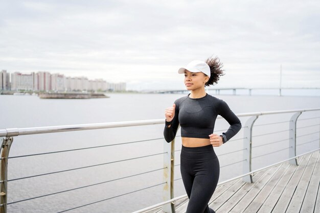 Running a female coach is actively engaged in sports runs in the city trains outdoors in sportswear