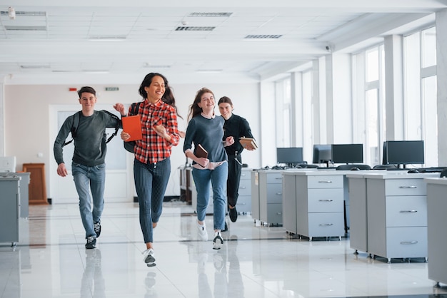 Correre in avanti. gruppo di giovani che camminano in ufficio durante la pausa
