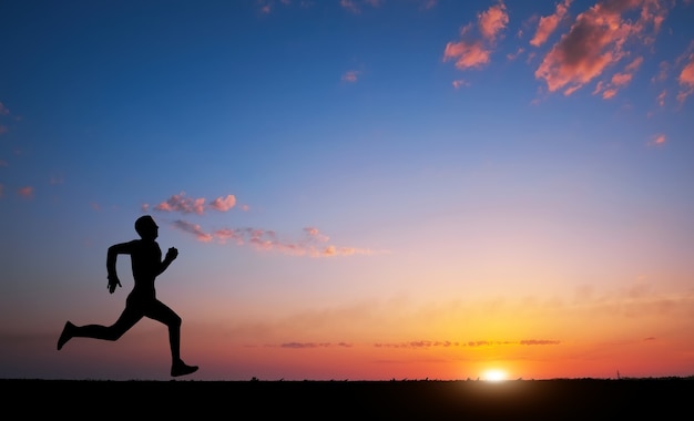 Siluetta corrente dell'uomo nell'ora del tramonto. sport e concetto di vita attiva