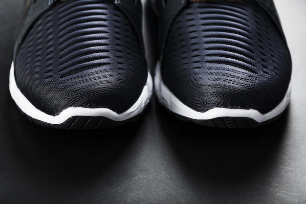 Running shoes with mesh and black and white soles close-up on a\
dark background. top view of sports sneakers.