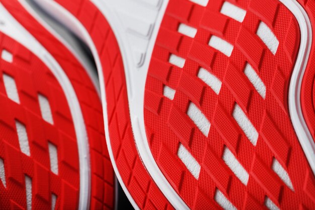 Running shoes with red soles on a black background. Close-up, top view