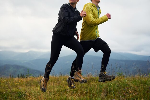 Running together Couple doing fitness Majestic Carpathian Mountains Beautiful landscape of untouched nature