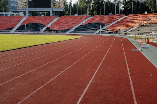 Беговые дорожки крупным планом на стадионе во время заката Спортивные сооружения для бега
