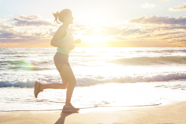 Donna in esecuzione sul movimento della spiaggia del mare ragazza che pareggia sulla costa del mare in mattinata soleggiata di estate fitness stile di vita sano