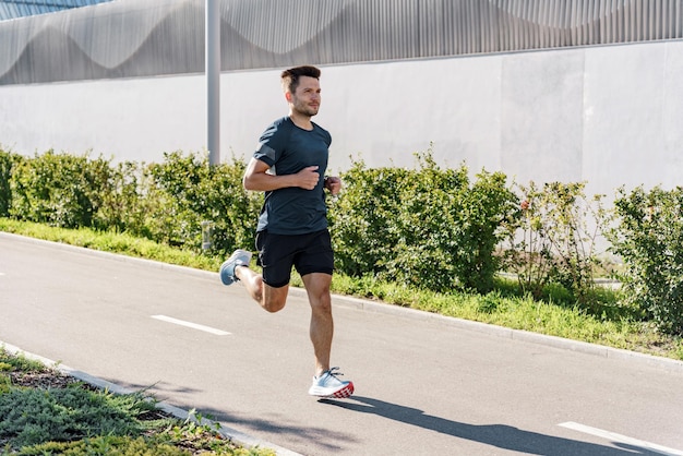 Runs alone on a treadmill in the city Active lifestyle and motivation A young man jogging in Tshirt