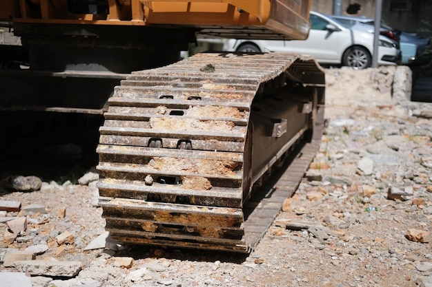 Rupsen van een bouwgraafmachine in het zand op een bouwplaats