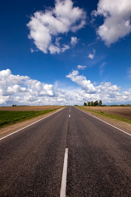 The rural not asphalted road which is passing across the field