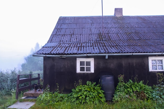 Rural house in a fog in summer evening