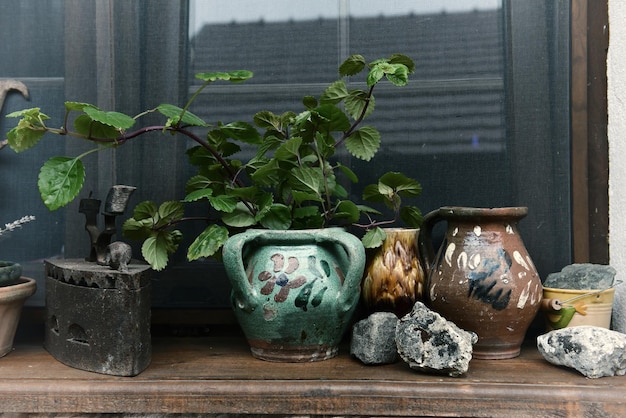 Rural house window and old jugs clay pots and iron