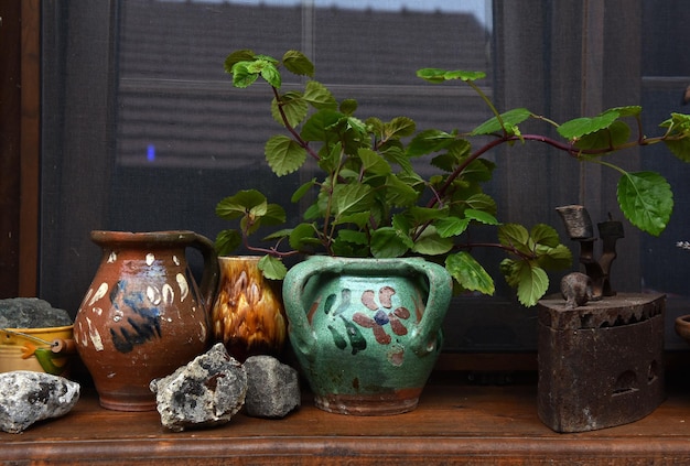 Rural house window and old jugs clay pots and iron