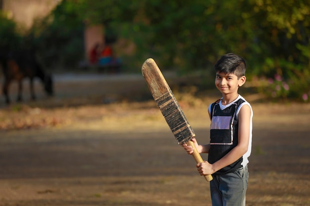 Foto bambino indiano rurale che gioca cricket