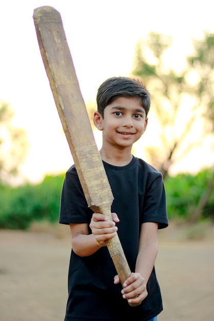 Bambino indiano rurale che gioca cricket