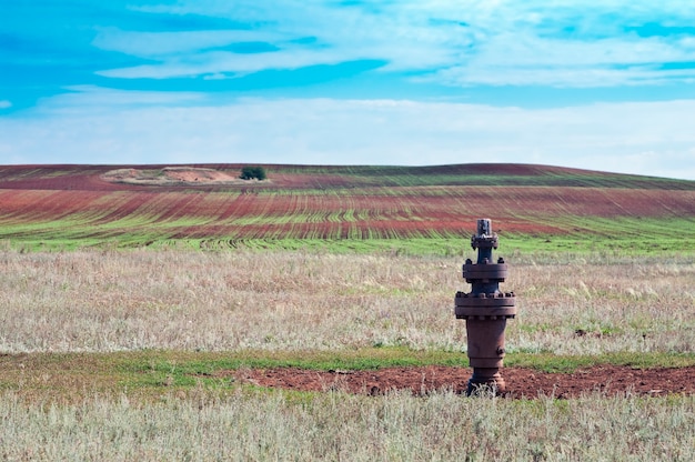 Сельский пейзаж, консервная нефтяная скважина на переднем плане