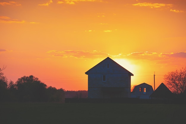 Paesaggio rurale la sera al tramonto silhouette di un villaggio contro il bel cielo serale